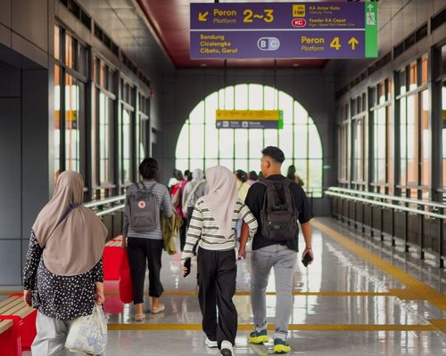 People walking calmly near a modern public transport station in Indonesia
